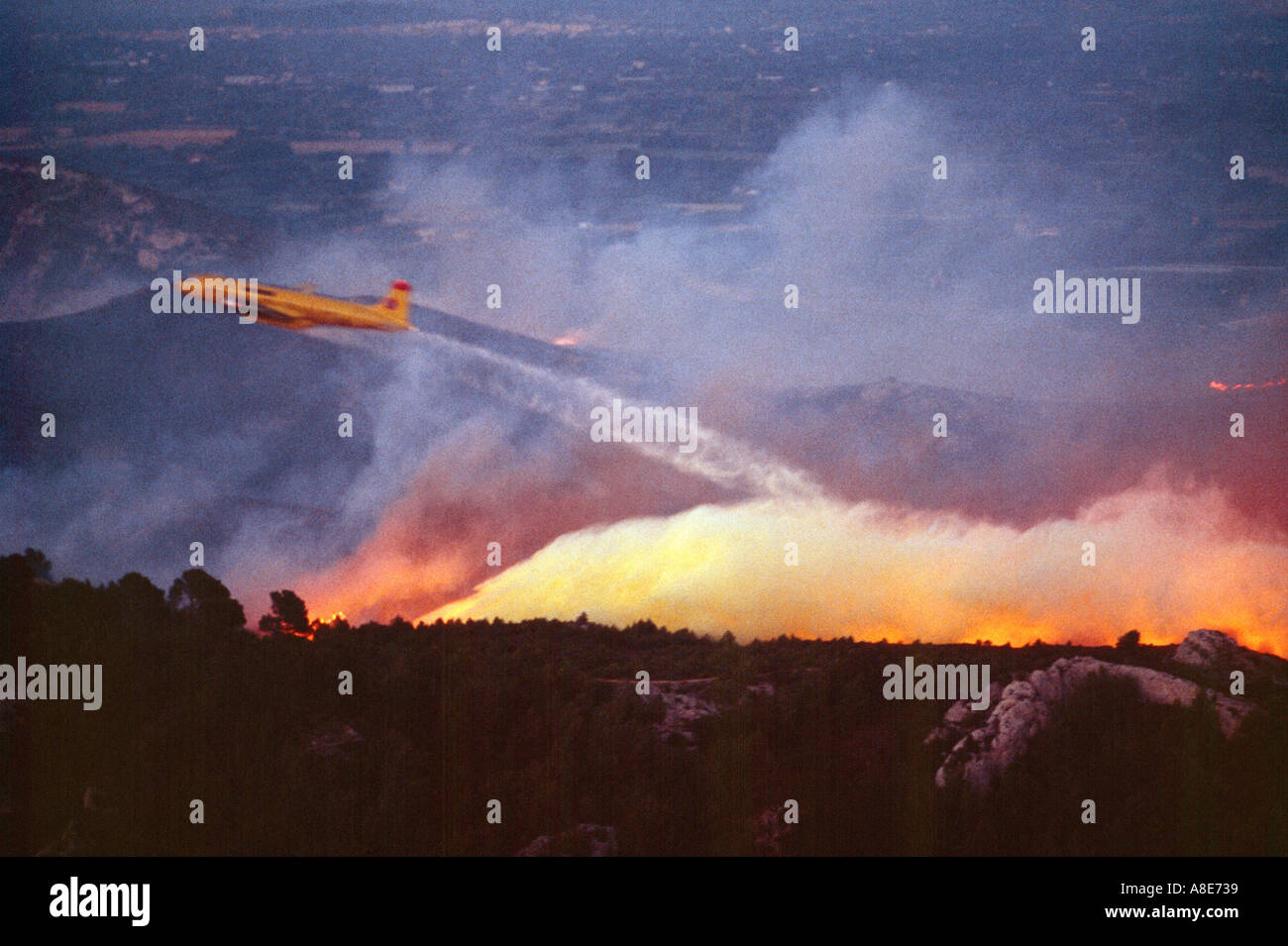 Vue aérienne d'un Douglas DC-6B avion bombardier d'eau de lutte contre l'abandon au feu sur une forêt au crépuscule, flammes, Provence, France, Europe, Banque D'Images