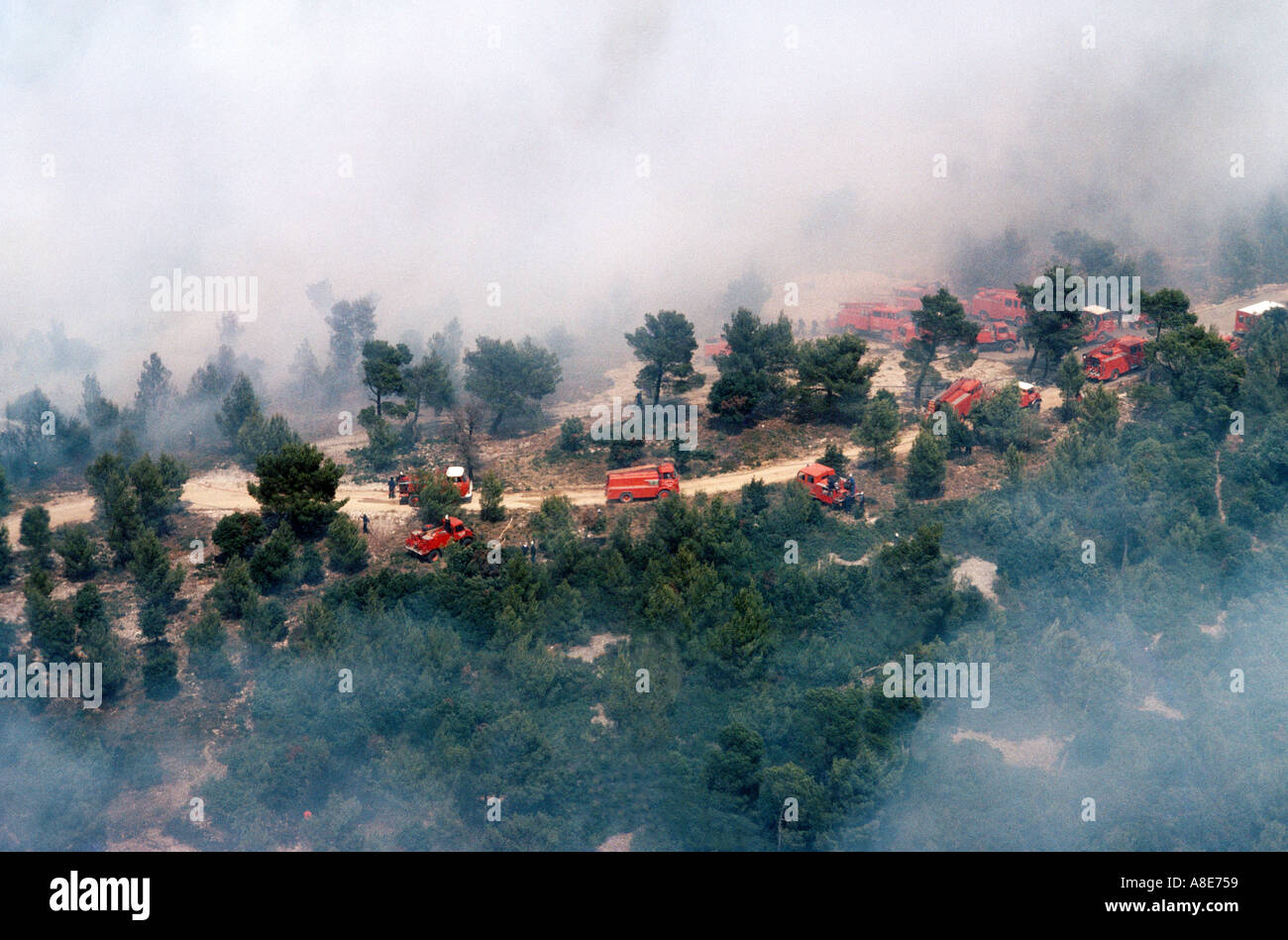 Vue aérienne de pompiers d'un feu rouge lutte contre les camions, la fumée provenant des feux de forêt, chemin de terre, Provence, France, Europe, Banque D'Images