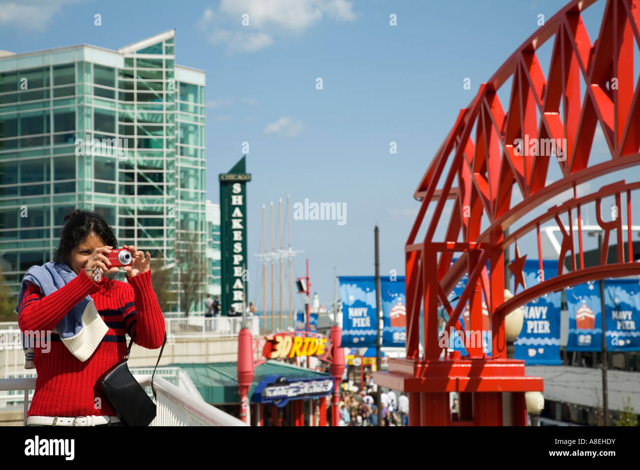 CHICAGO Illinois Femme chandail rouge rouge utiliser Appareil photo pour prendre photo Shakespeare Theatre à Navy Pier en arrière-plan Banque D'Images