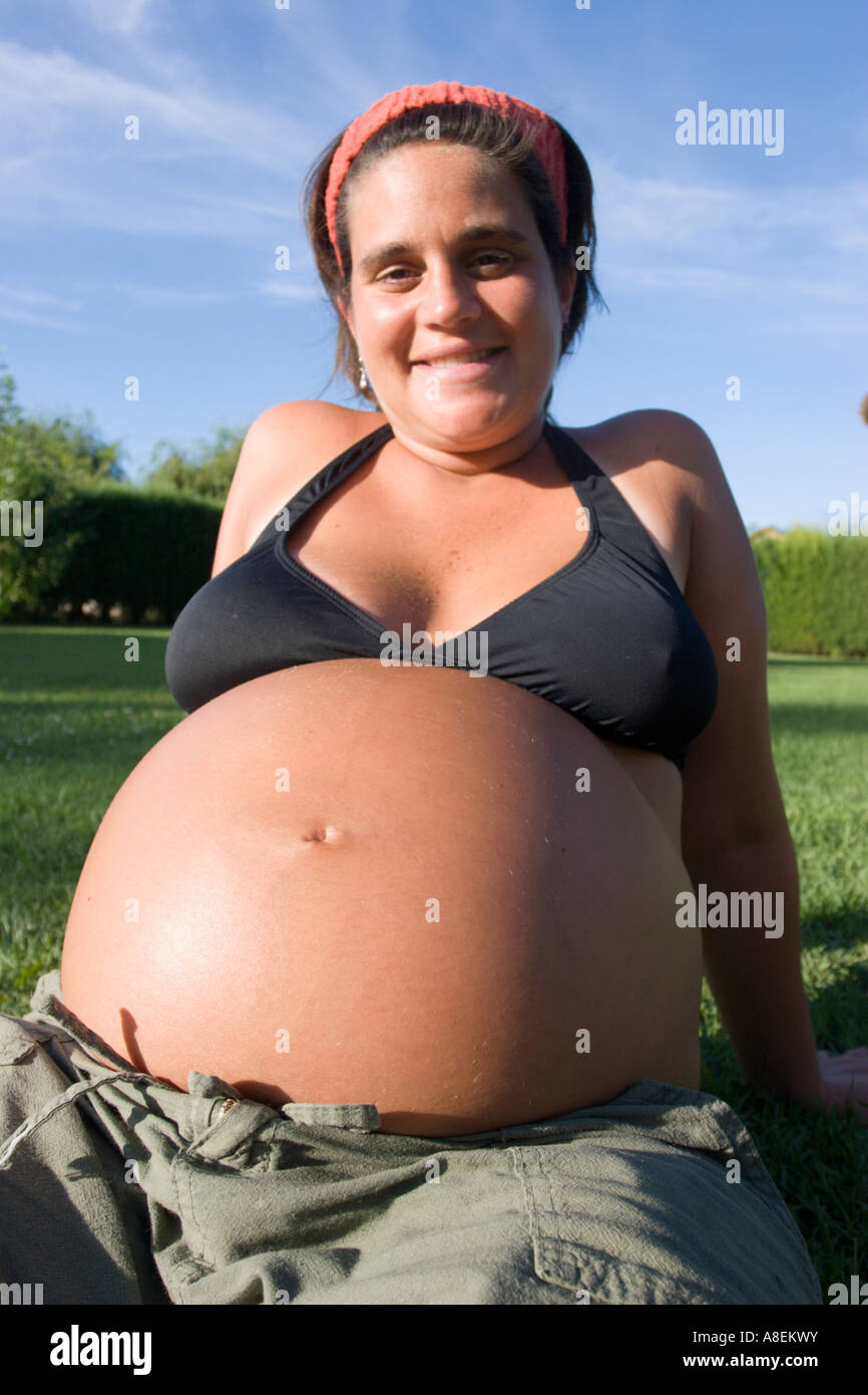 Jeune femme enceinte prévue sur l'herbe avec un gros ventre Photo Stock -  Alamy