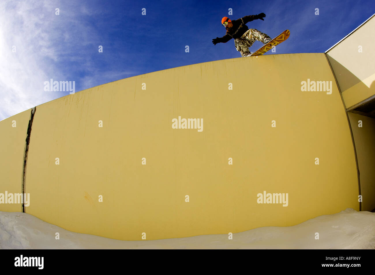 Le surfeur urbain passant un mur dans le village de ski Banque D'Images