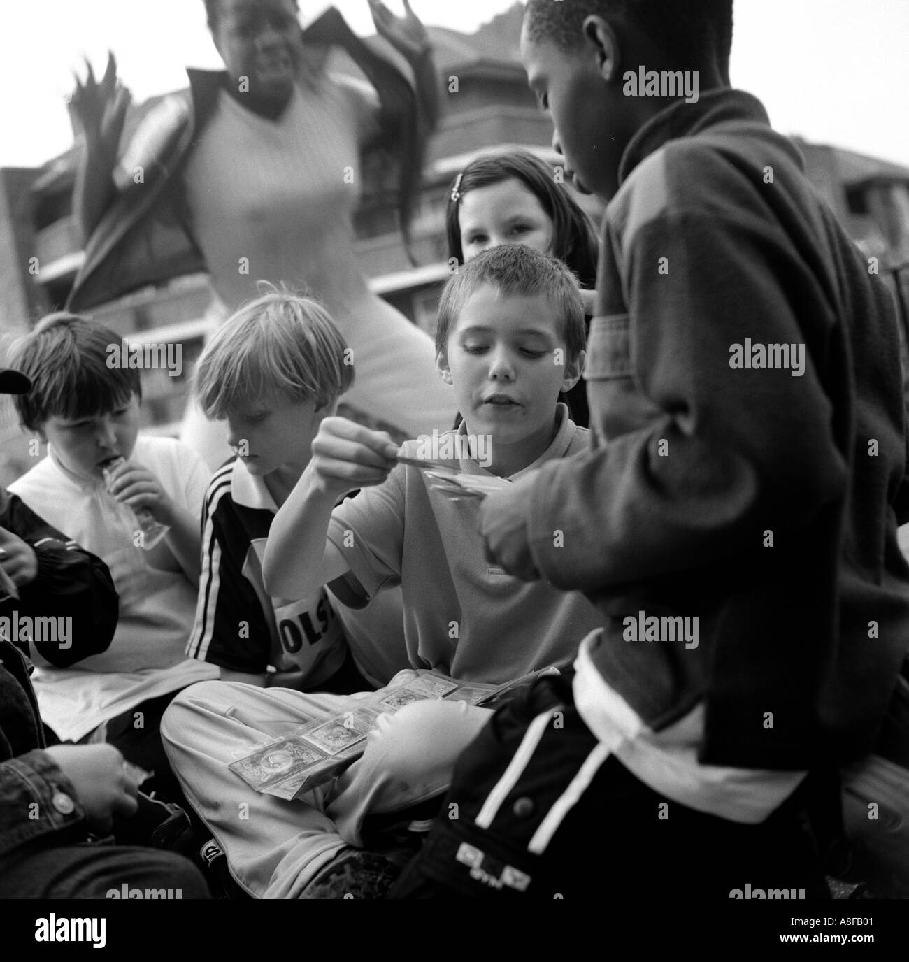 De jeunes enfants jouant avec des cartes Pokemons sur leur conseil estate Clapton, Londres, Royaume-Uni. Banque D'Images