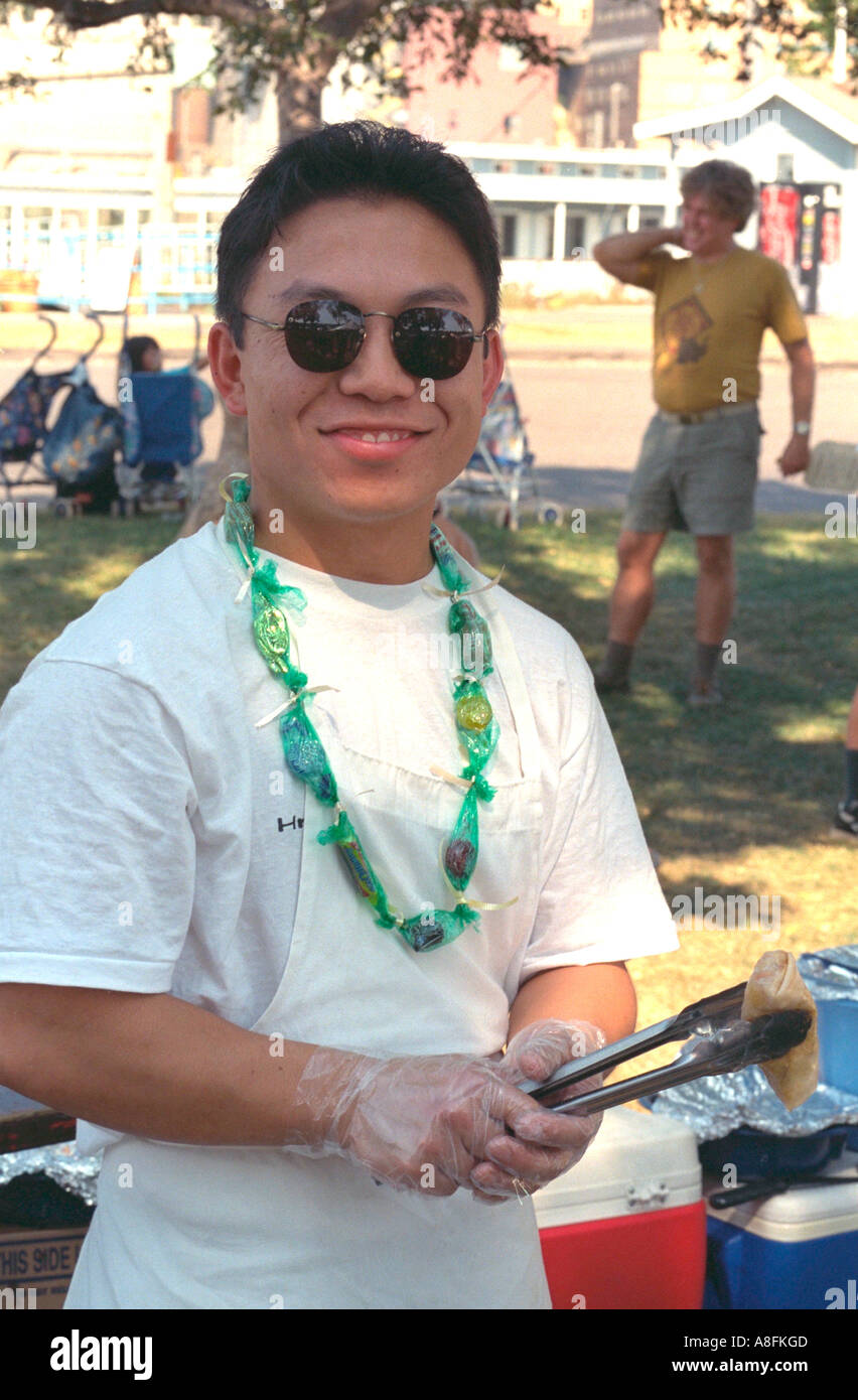 Heureux homme asiatique de 21 ans la cuisson egg rolls au kiosque. State Fair St Paul Minnesota USA Banque D'Images