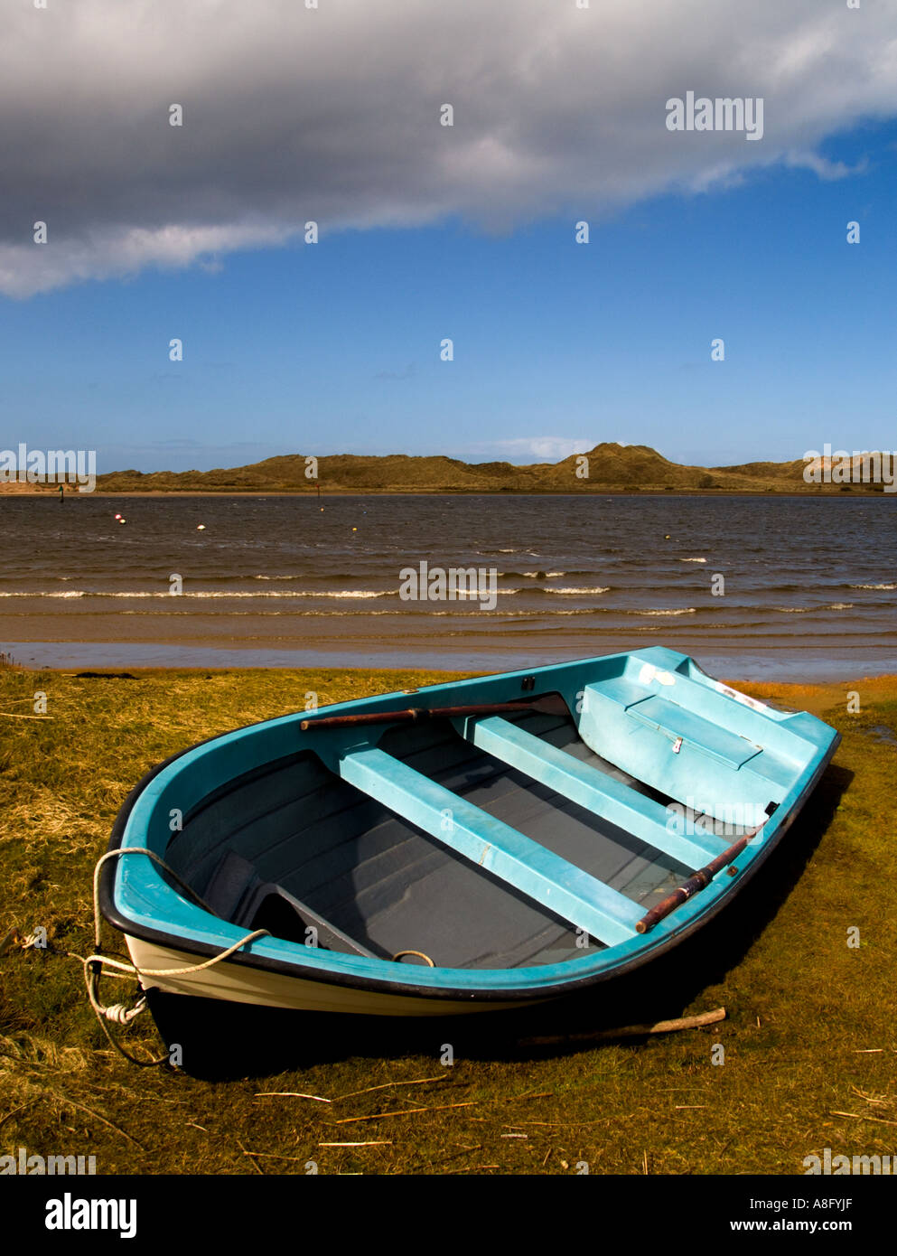 Un petit bateau à rames se trouve sur les rives de la basse rivière Bann Castlerock à Irlande du Nord Banque D'Images