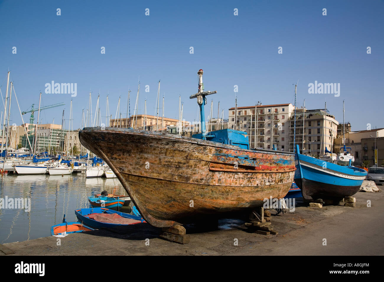Vieux bateau de pêche en bois en cours de rénovation à la marina à quai à La Cala Palerme Sicile Italie Banque D'Images