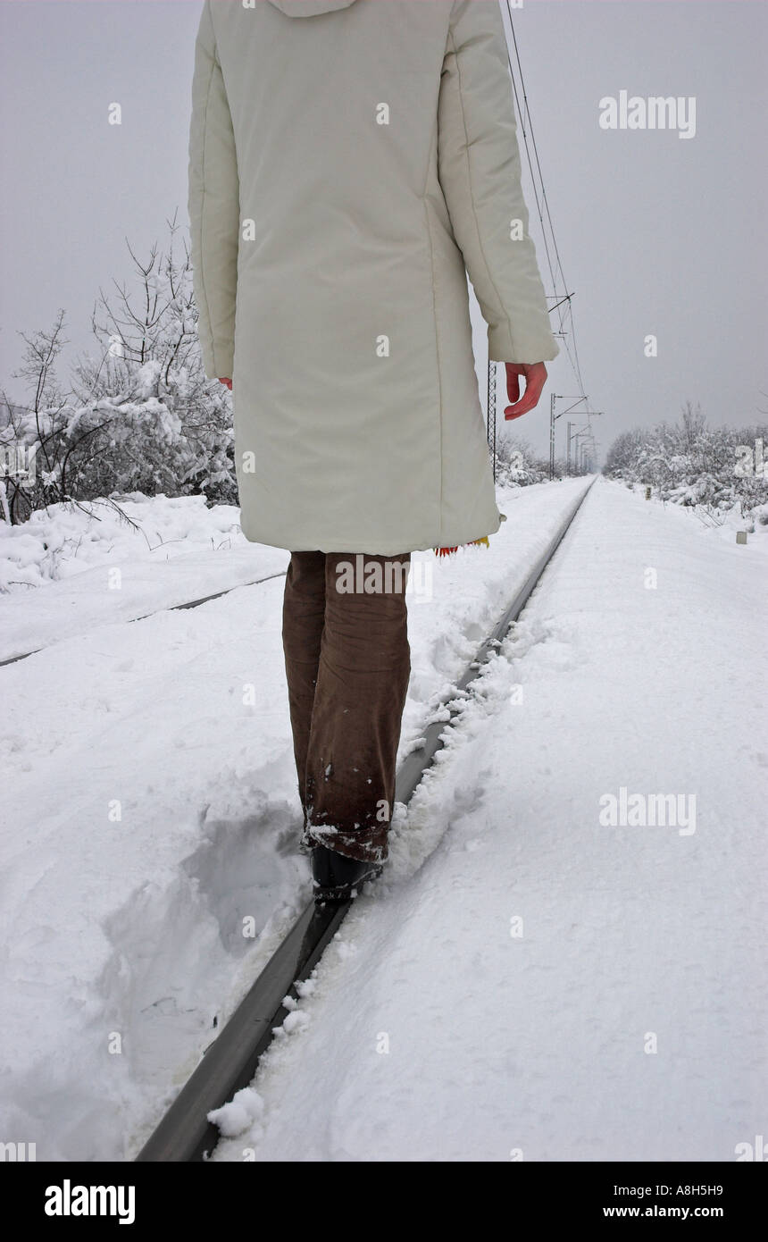 Jeune femme marche sur des rails de chemin de fer Banque D'Images