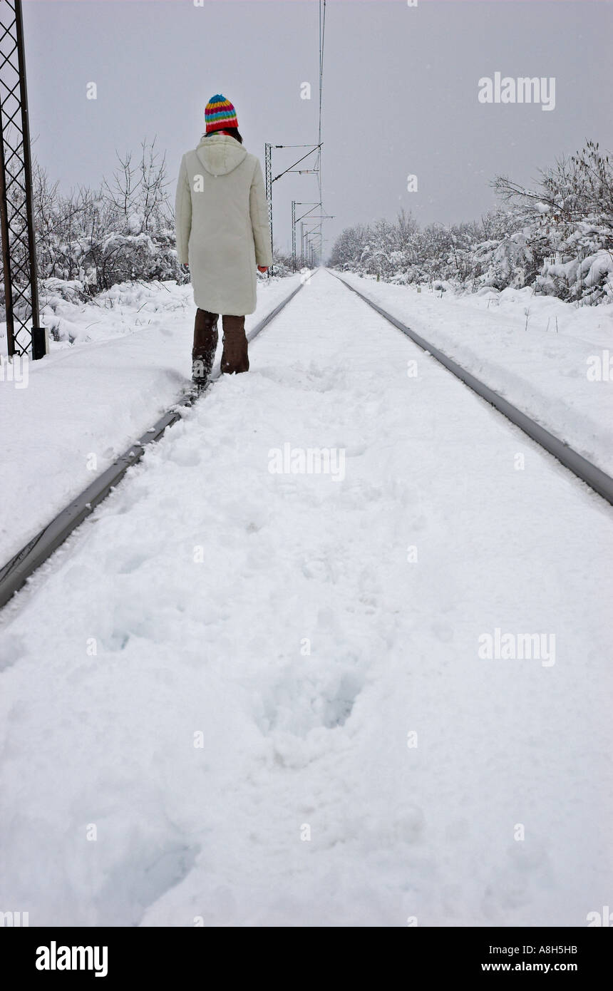 Jeune femme marche sur des rails de chemin de fer Banque D'Images