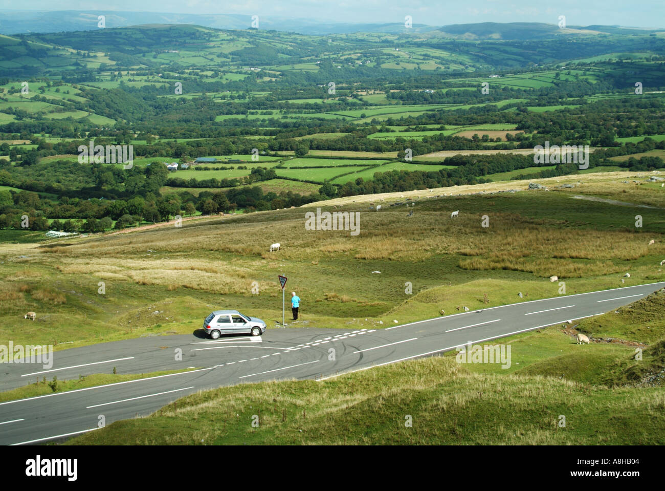 Le Parc National des Brecon Beacons non clôturé calme route avec voiture solitaire à la jonction de la lande de transition agriculture Carmarthenshire South Wales UK Banque D'Images