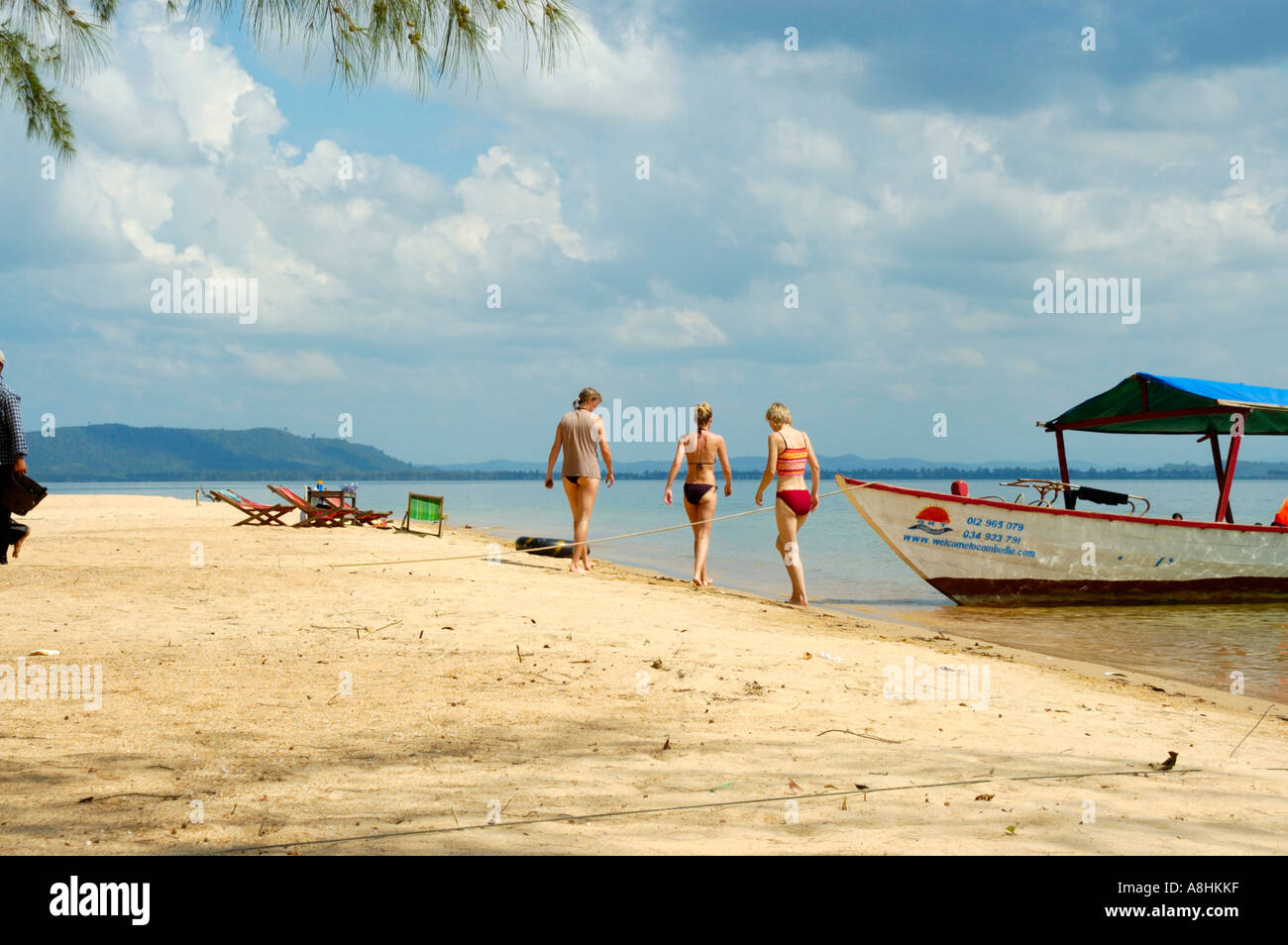 Trois jeunes femmes maigre lors d'une plage de sable fin avec un bateau Bamboo Island Sihanoukville Cambodge Kompong Som Banque D'Images