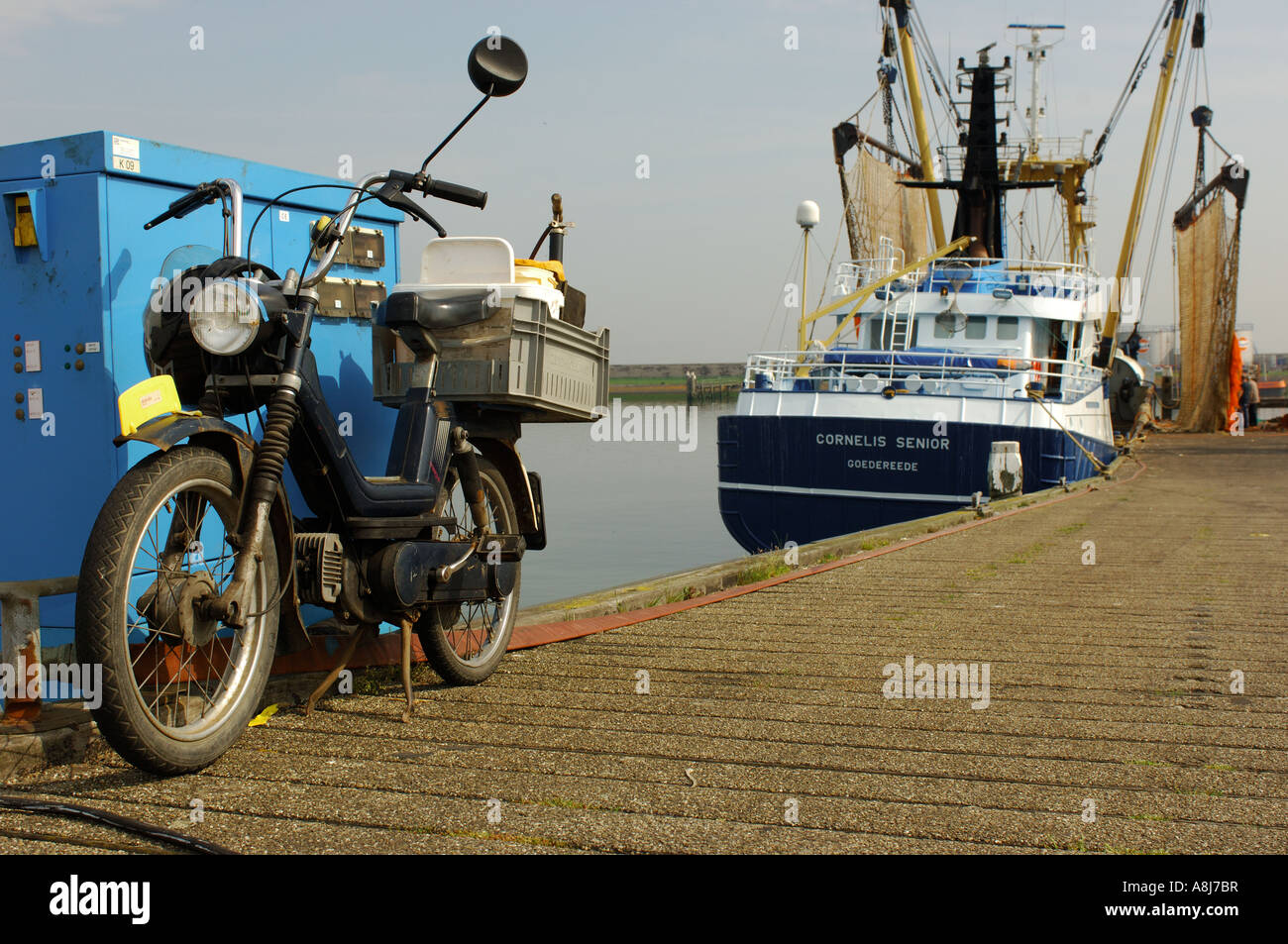 Cyclomoteur hommes pêcheur dans le port de Stellendam bleu blanc de la jetée Banque D'Images