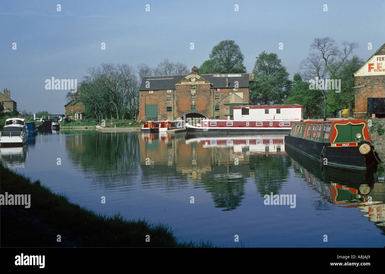 Le canal Trent à Cavendish Bridge avec F E Steven s moulin à maïs et amarré bateaux étroits Derbyshire Banque D'Images