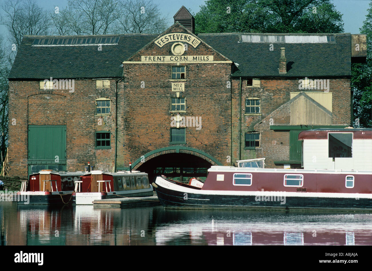 Le canal Trent à Cavendish Bridge avec F E Steven s moulin à maïs et amarré bateaux étroits Derbyshire Banque D'Images