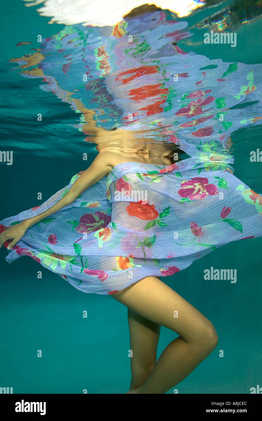 Femme avec paréo de lavande sous l'eau à la piscine Banque D'Images