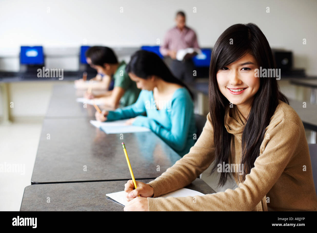 Portrait d'une jeune femme les examens donnant dans une salle de classe et souriant Banque D'Images