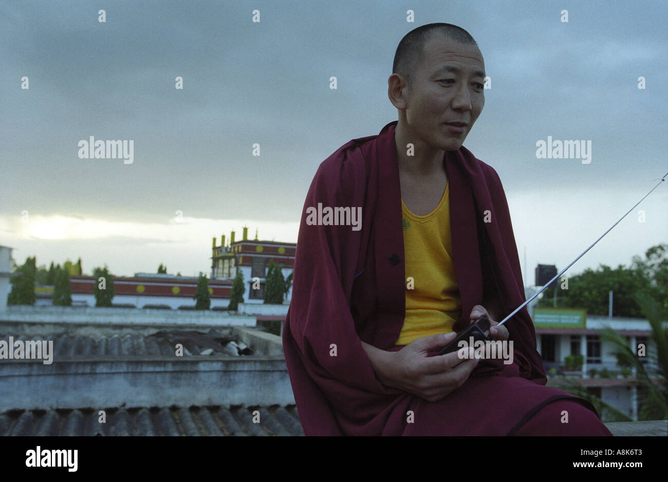 Un moine tibétain à l'écoute des nouvelles du monde extérieur via la radio à ondes courtes. Banque D'Images