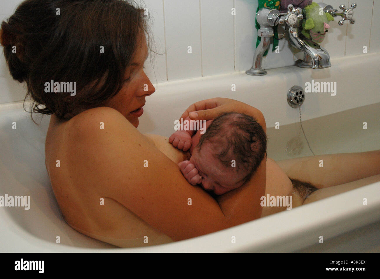 Mère de détente avec baignoire bébé après homebirth. Banque D'Images