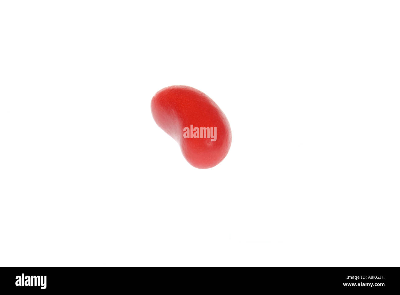 Close up horizontale d'un seul red jelly bean sur un fond blanc. Banque D'Images