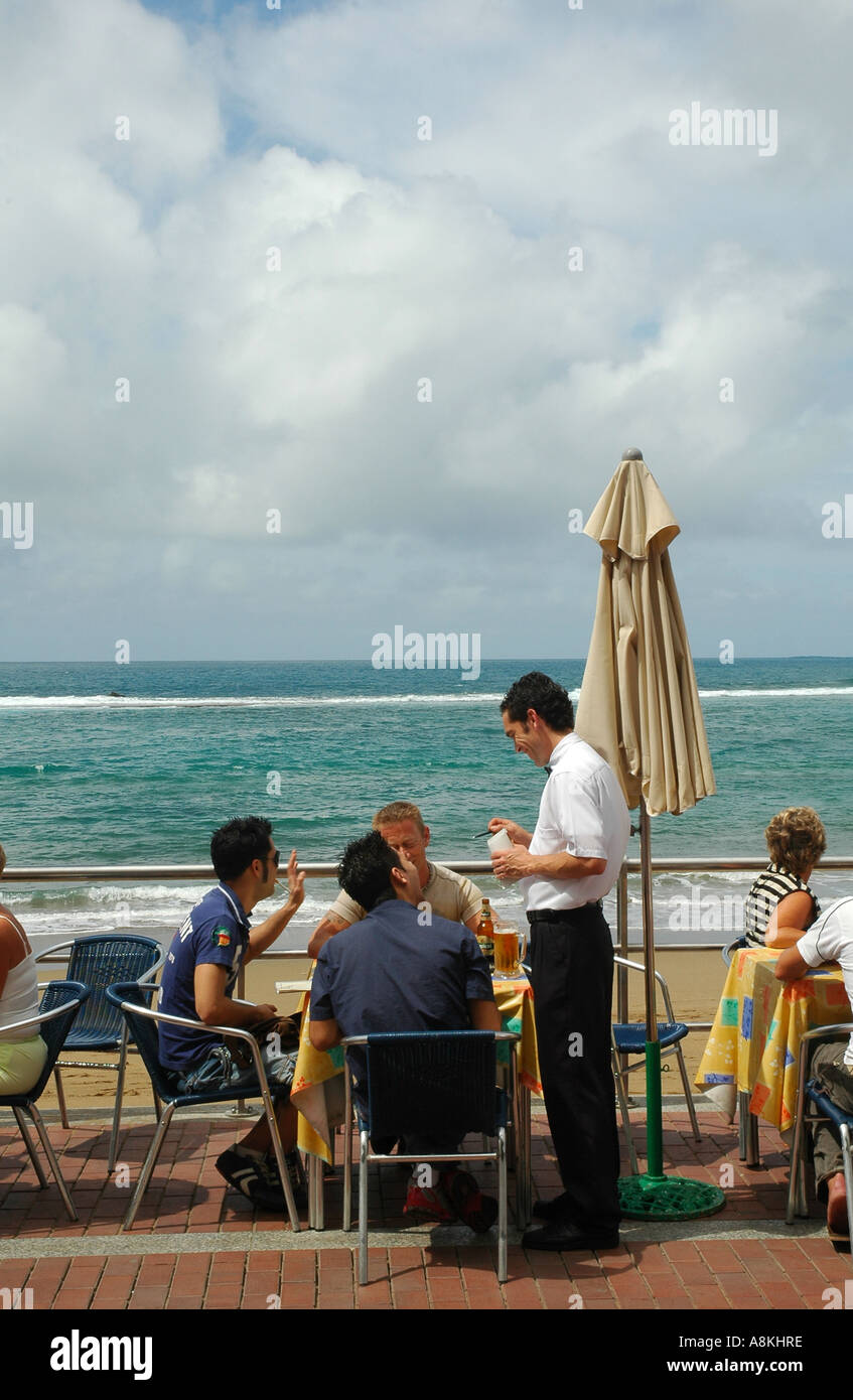 Les gens s'assoient dans un restaurant au bord de la plage de Playa de Las  Canteras, dans la capitale de Las Palmas, l'île de Gran Canaria, l'une des  îles Canaries d'Espagne Photo