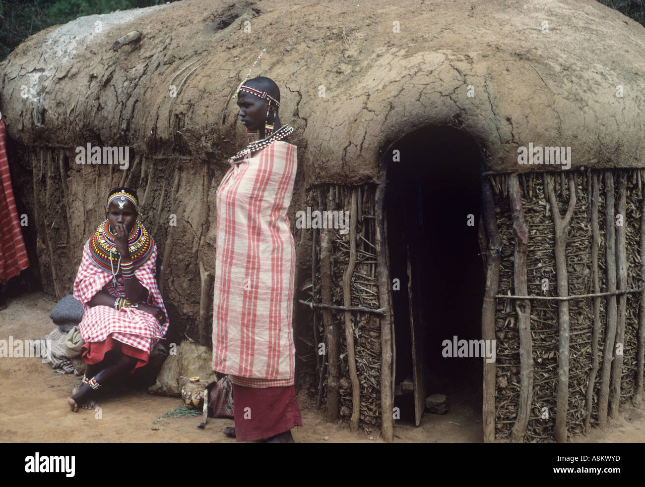 Manyatta masaï avec des femmes en dehors de leur hutte, Kenya Banque D'Images