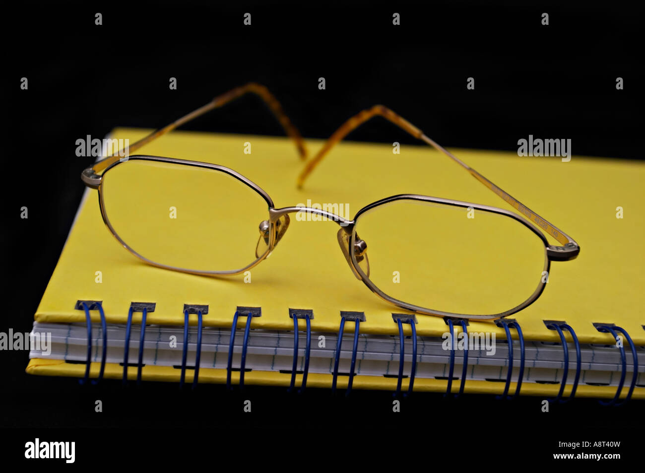 Paire de lunettes lunettes de lecture reposant sur un carnet jaune Banque D'Images