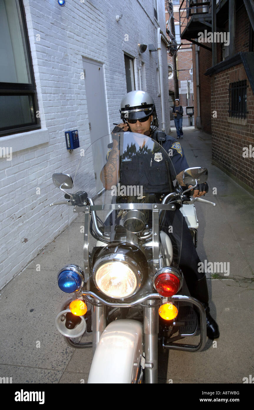 Moto hispanique sur sa Harley Davidson policier parle de vélo sur la radio  dans une ruelle étroite Photo Stock - Alamy