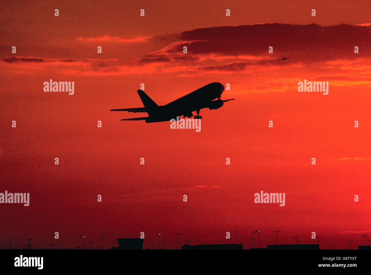 Avions commerciaux décollant au coucher du soleil. Banque D'Images