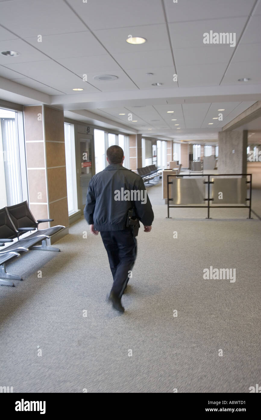 Agent de police de l'aéroport d'arrivée en s'assurant que les portes sont verrouillées et l'aéroport international de Kansas City USA Banque D'Images