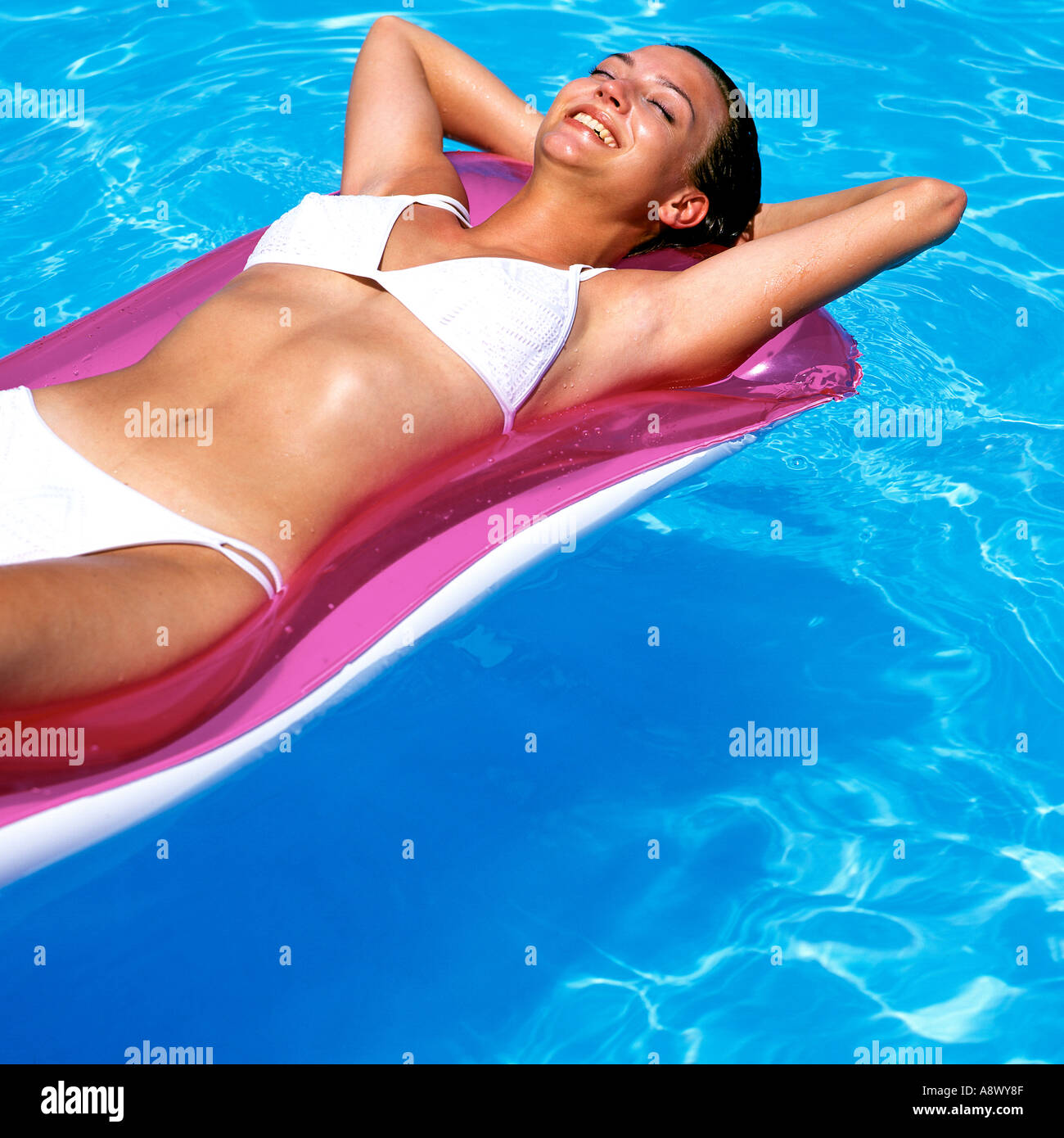 Femme sur LILO dans la piscine Banque D'Images