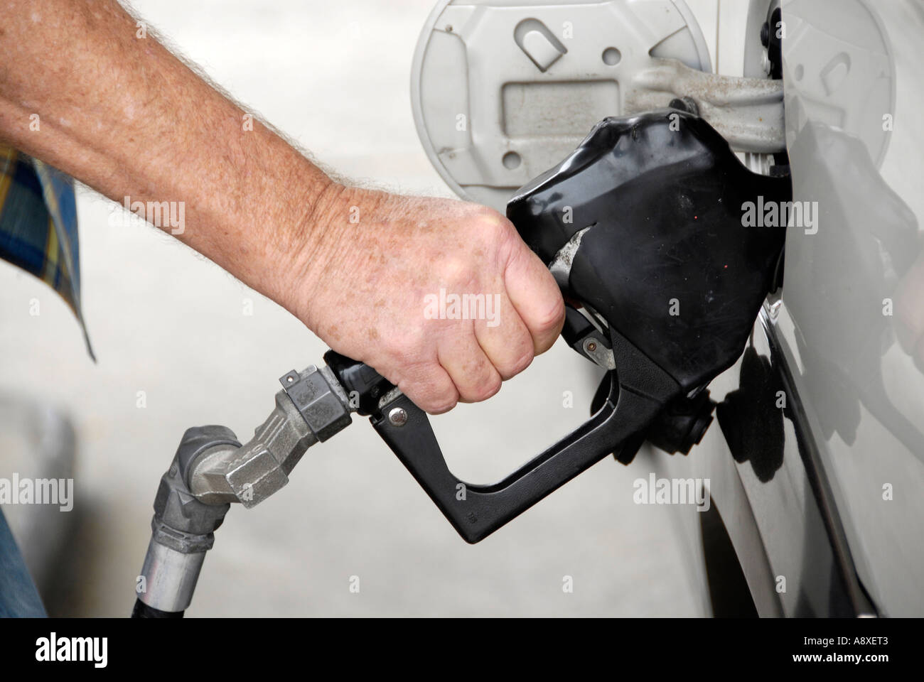 Pompes mâles adultes gaz dans sa voiture à une station-service Banque D'Images