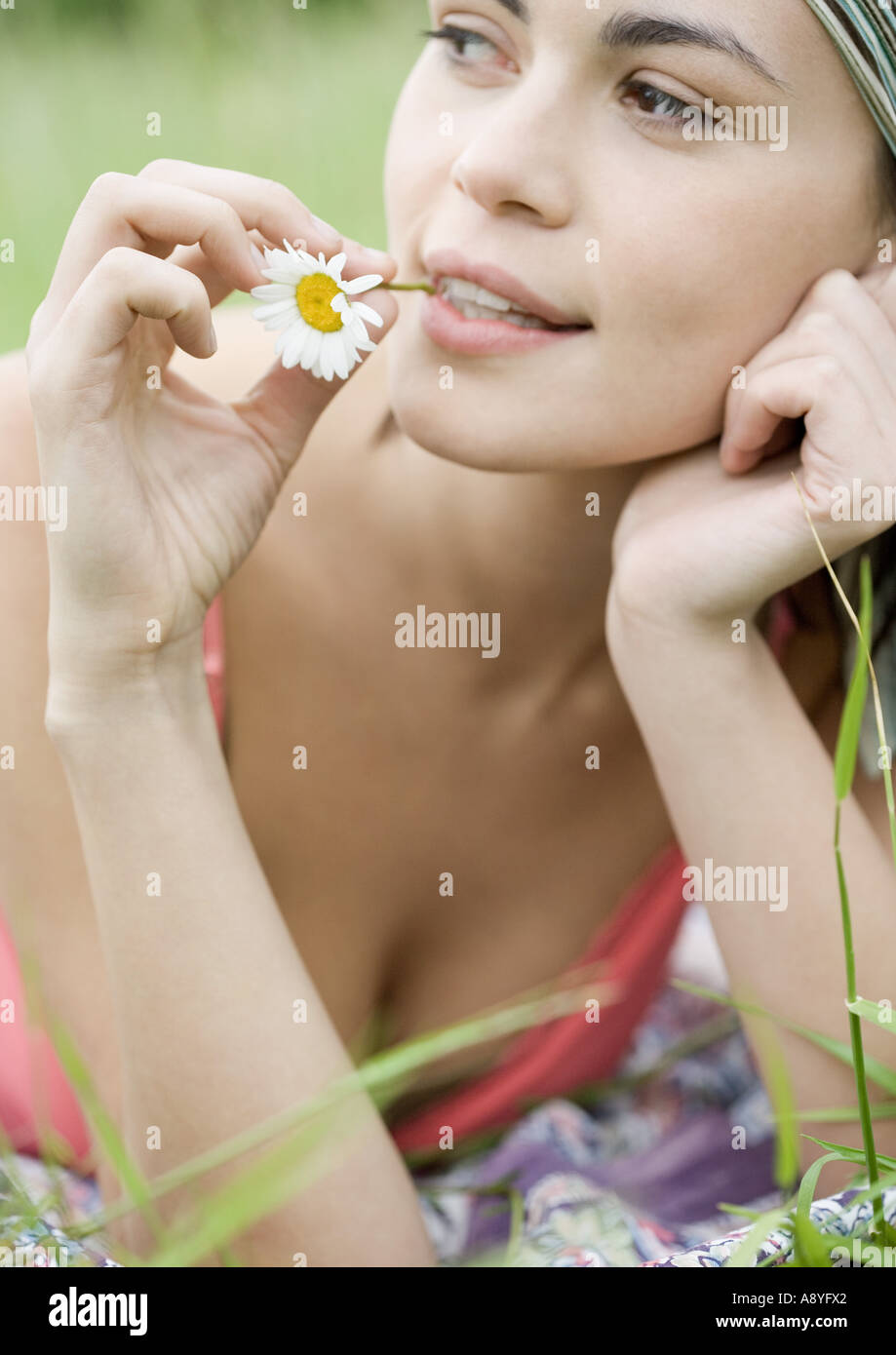 Jeune femme avec tige florale en bouche Banque D'Images