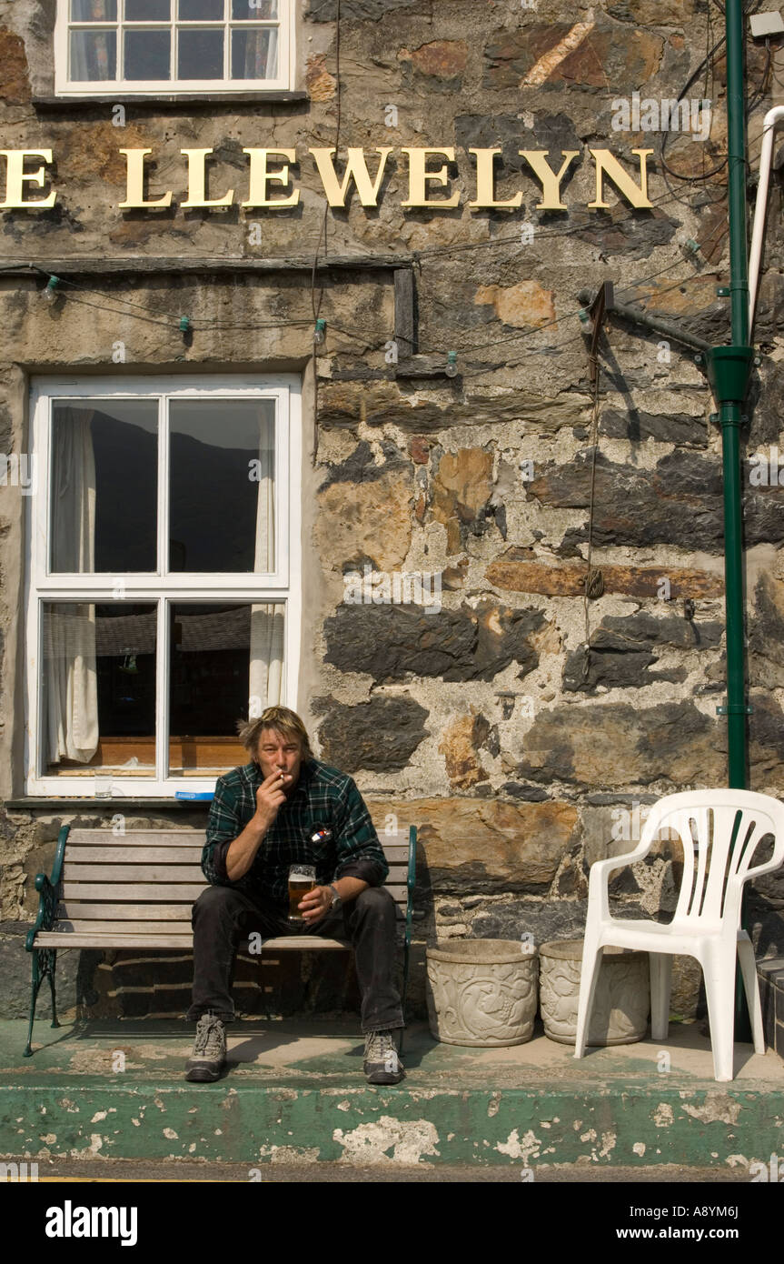 L'homme de boire et de fumer la cigarette à l'extérieur de Prince Llewelyn pub snowdonia national park de Beddgelert Gwynedd au nord du Pays de Galles Banque D'Images