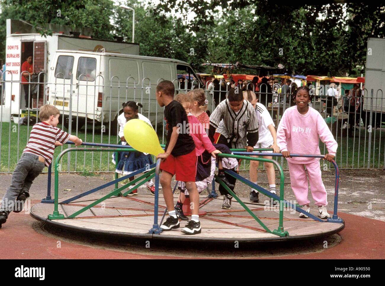 Les enfants jouant sur les rond-point aire Banque D'Images