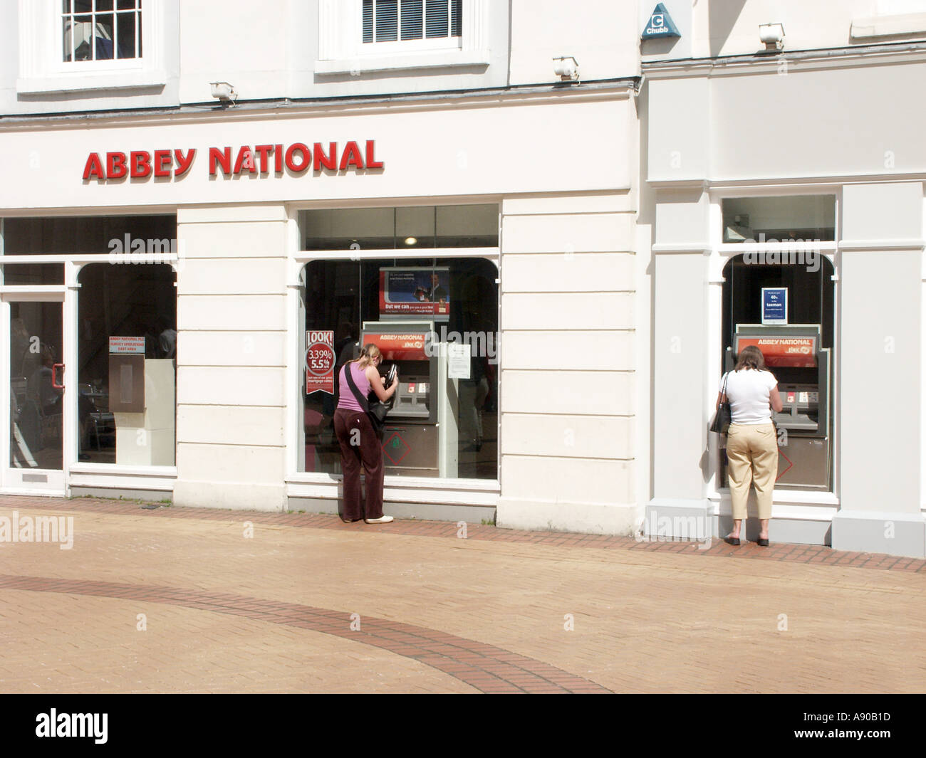 Les femmes les clients à l'extérieur des locaux de la direction générale de la Banque Abbey National en utilisant le trou dans le mur externe cash machine points Chelmsford Essex England UK Banque D'Images