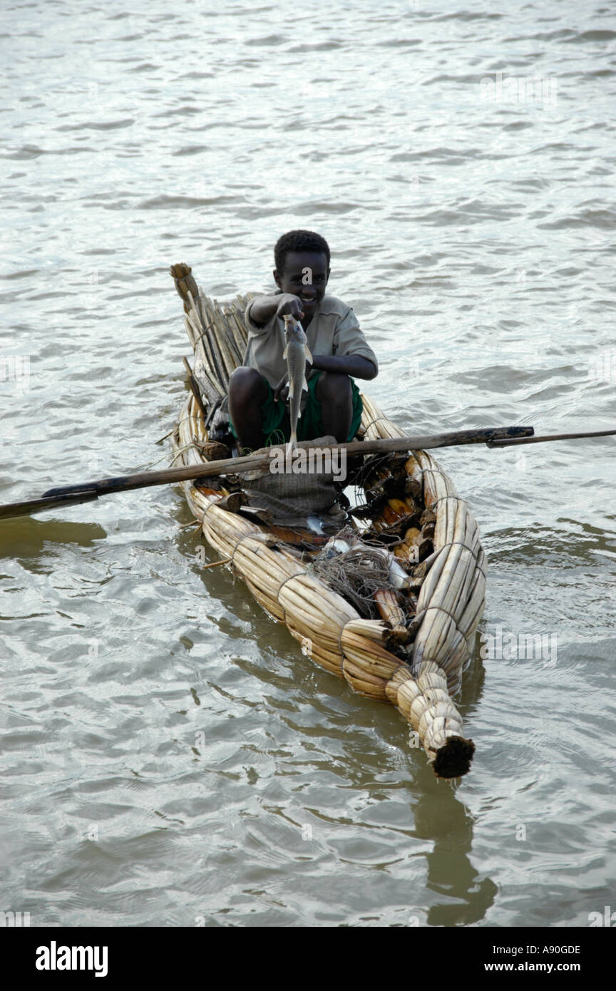 Jeune pêcheur avec un poisson pris dans un papyrus bateau sur le lac Tana, près de Bahir Dar Ethiopie Banque D'Images