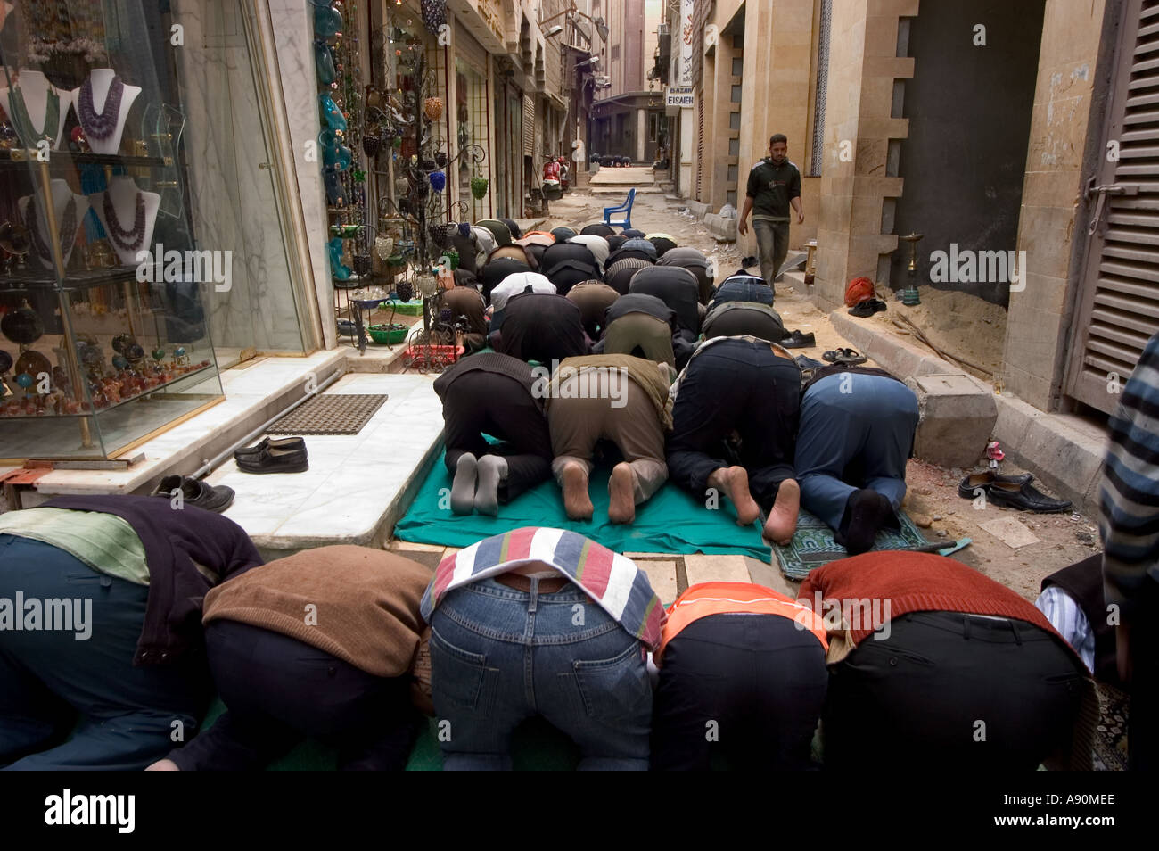 Les fidèles à genoux pour la prière scène de rue Le Caire islamique Le Caire Egypte Afrique du Nord Banque D'Images