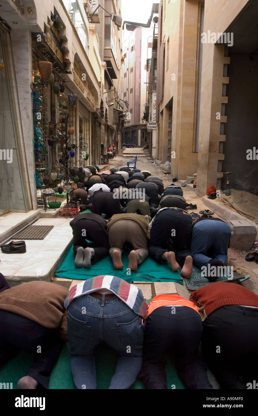 Les fidèles à genoux pour la prière scène de rue Le Caire islamique Le Caire Egypte Afrique du Nord Banque D'Images