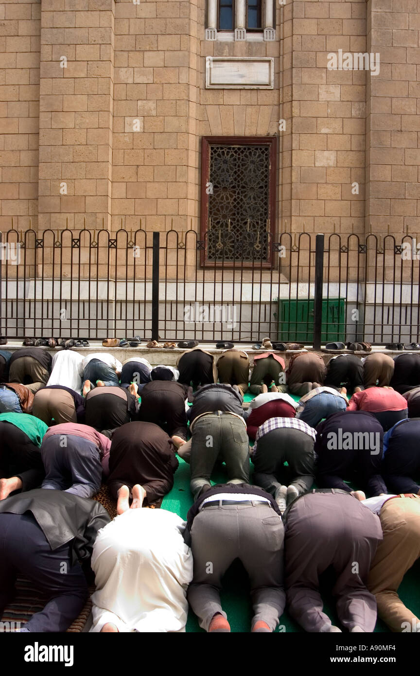 Les fidèles à genoux pour la prière scène de rue Le Caire islamique Le Caire Egypte Afrique du Nord Banque D'Images