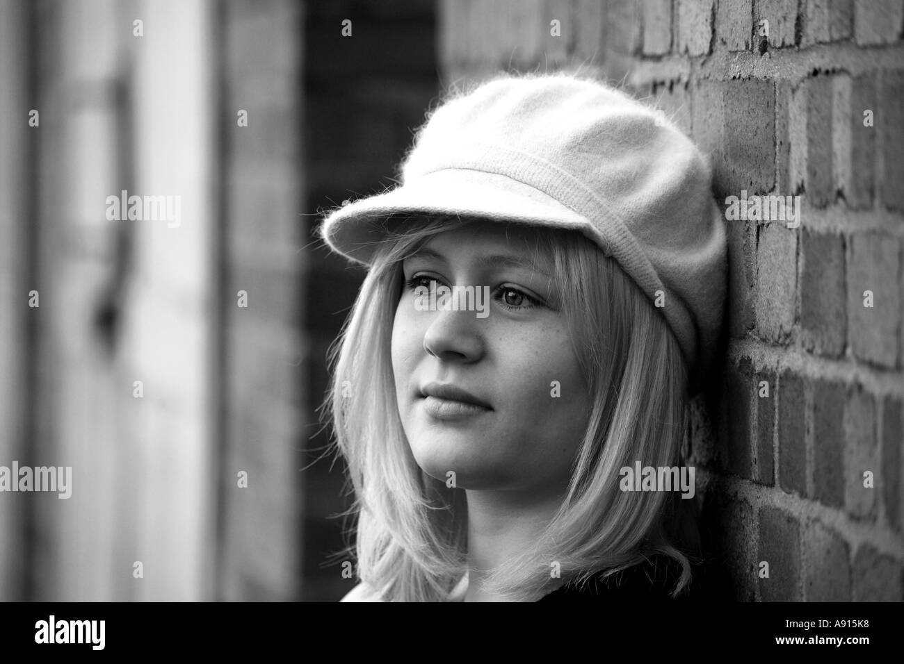 Horizontal noir et blanc portrait de jeune fille aux cheveux blonds en fluffy hat, en regardant l'humeur pensive Banque D'Images