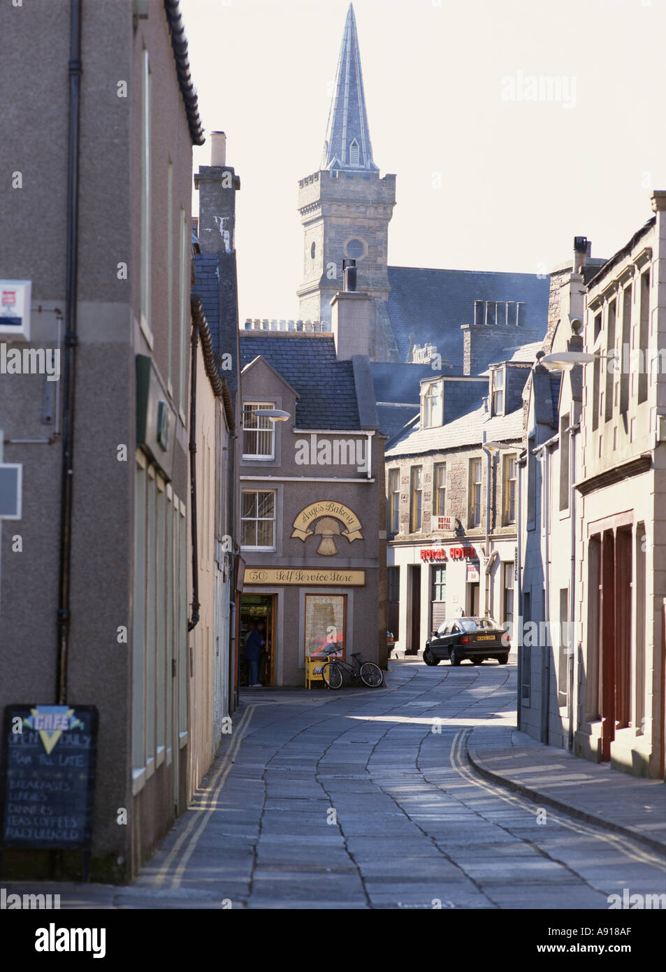 Dh, rue Victoria STROMNESS ORKNEY Argos baker shop ville rue principale clocher d'église Banque D'Images
