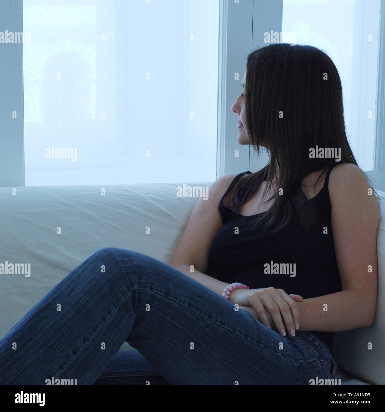 Portrait d'une femme à la fenêtre d'un air songeur Banque D'Images