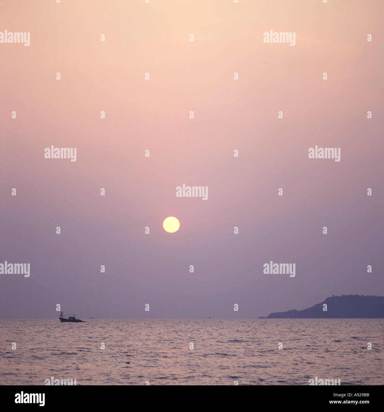Coucher de Bogmalo Beach avec un seul bateau de pêche dans la distance, Goa, Inde Banque D'Images