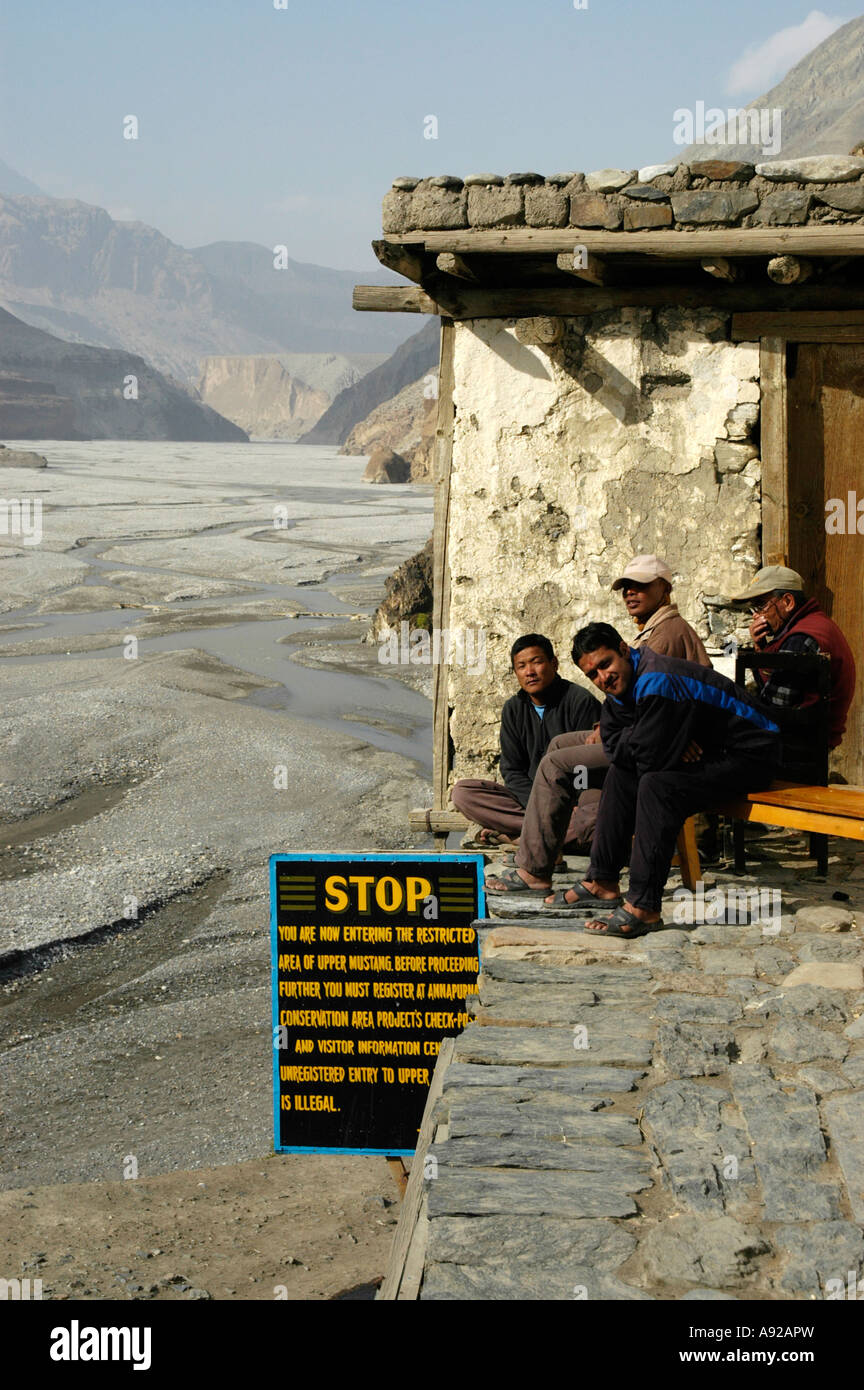 Les hommes s'asseoir à la police checkpost avec le signe une butée dans la région Upper Mustang Mustang Kagbeni Népal Région de l'Annapurna Banque D'Images