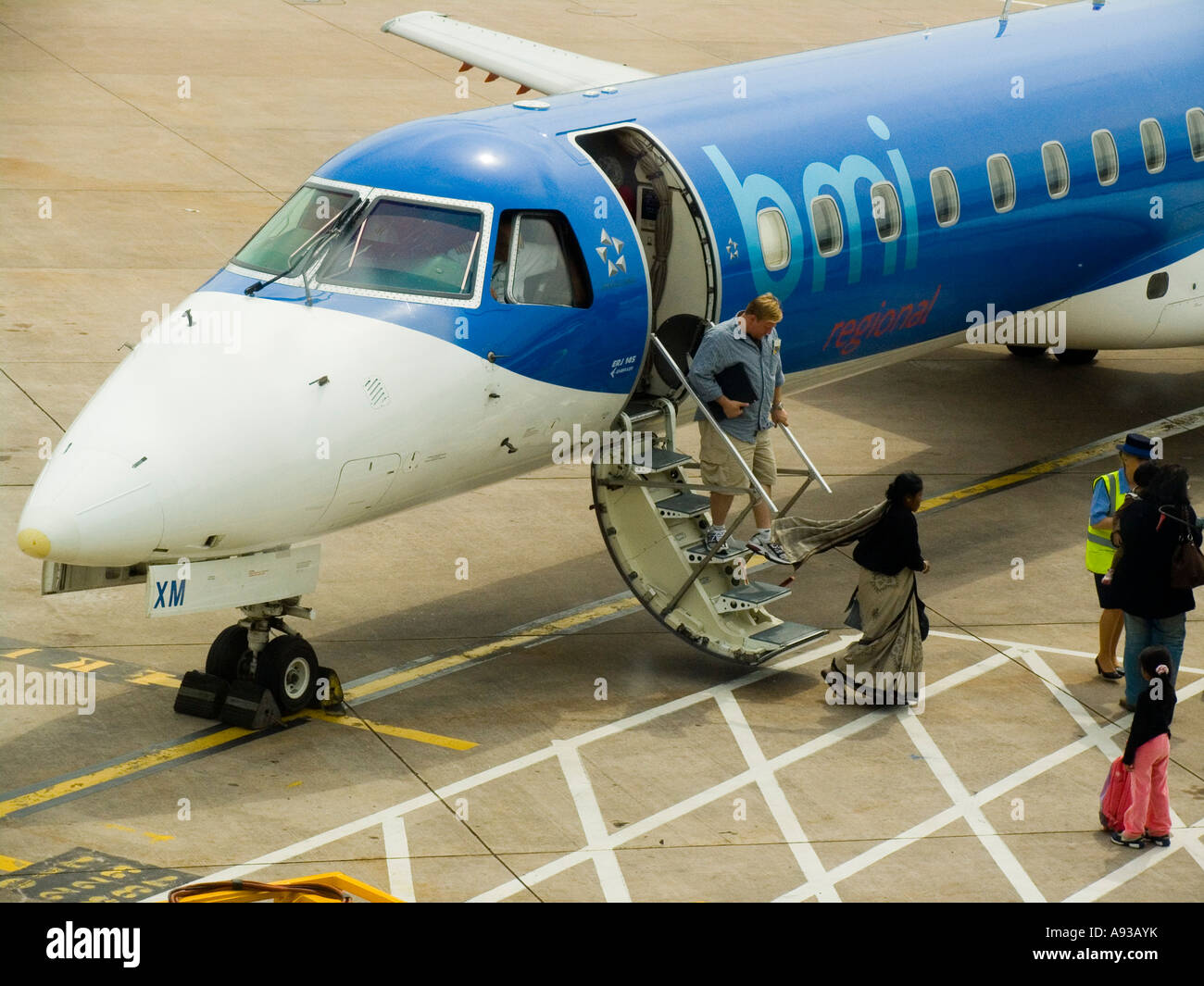 Les passagers débarquant d'un petit avion à réaction régional sur le tarmac de l'aéroport de Manchester Banque D'Images