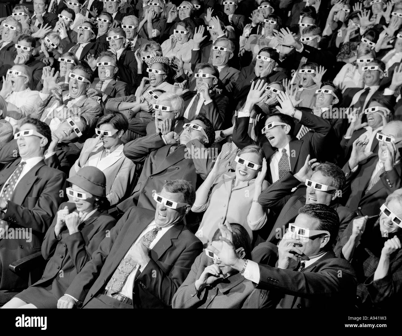 Portrait de groupe des spectateurs assis dans une salle de cinéma portant des lunettes 3-D Banque D'Images