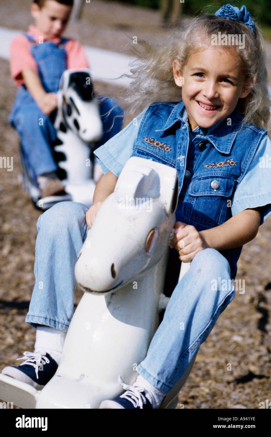 Deux filles assis sur des chevaux à bascule Banque D'Images