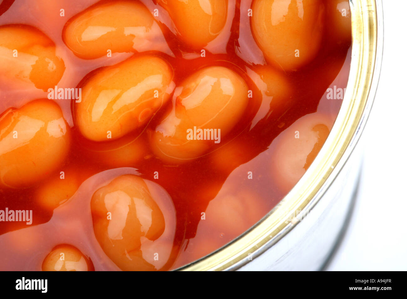 Ouverture du pot de élevée en fibres alimentaires des haricots blancs en sauce tomate isolé sur un fond blanc avec aucun peuple et un chemin de détourage Banque D'Images