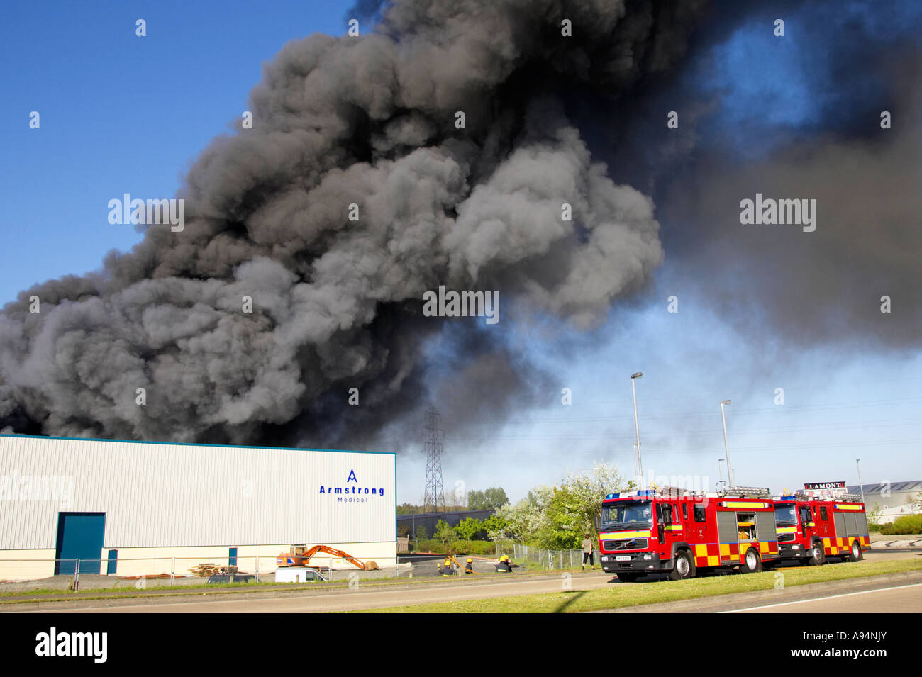 Les équipes de pompiers arrivant sous panache de fumée à l'incendie à l'entrepôt médical armstrong coleraine Banque D'Images