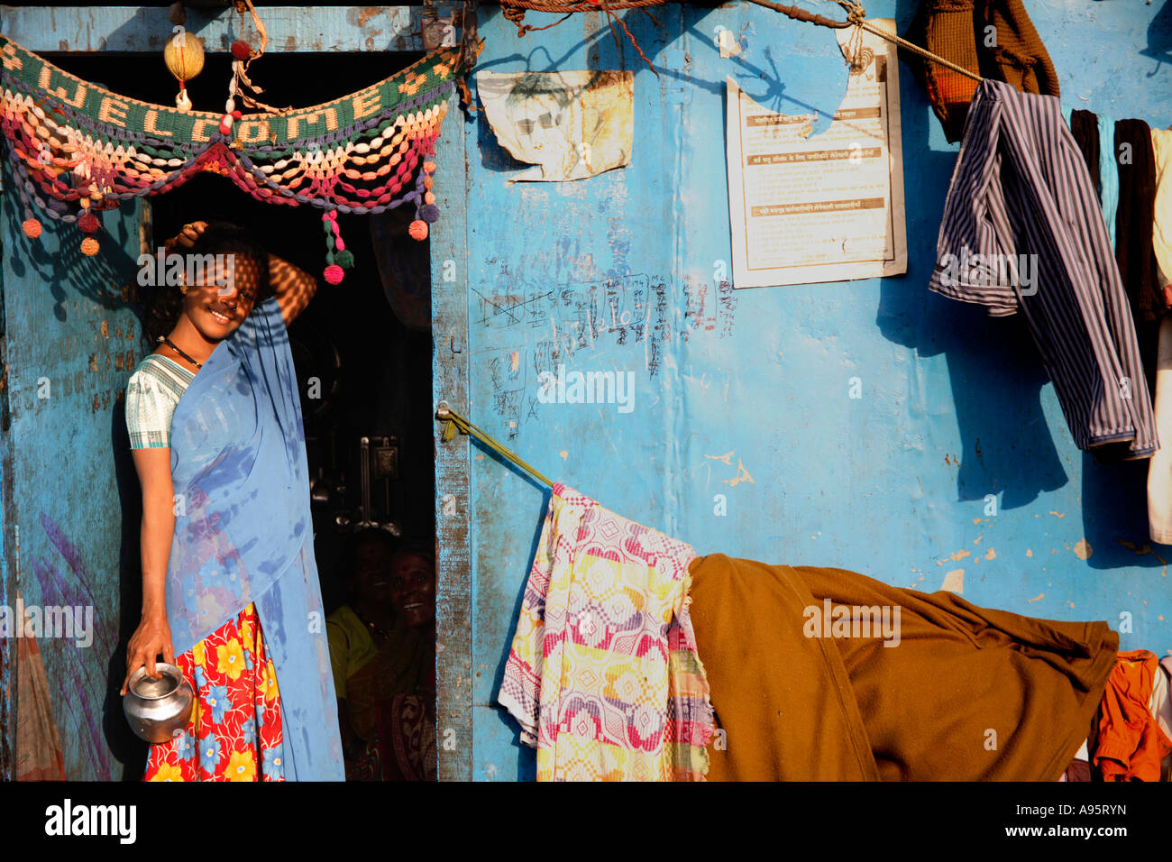 Jeune femme indienne posant à la porte de sa maison miteuse, d'Mello Road, Mumbai, Inde Banque D'Images