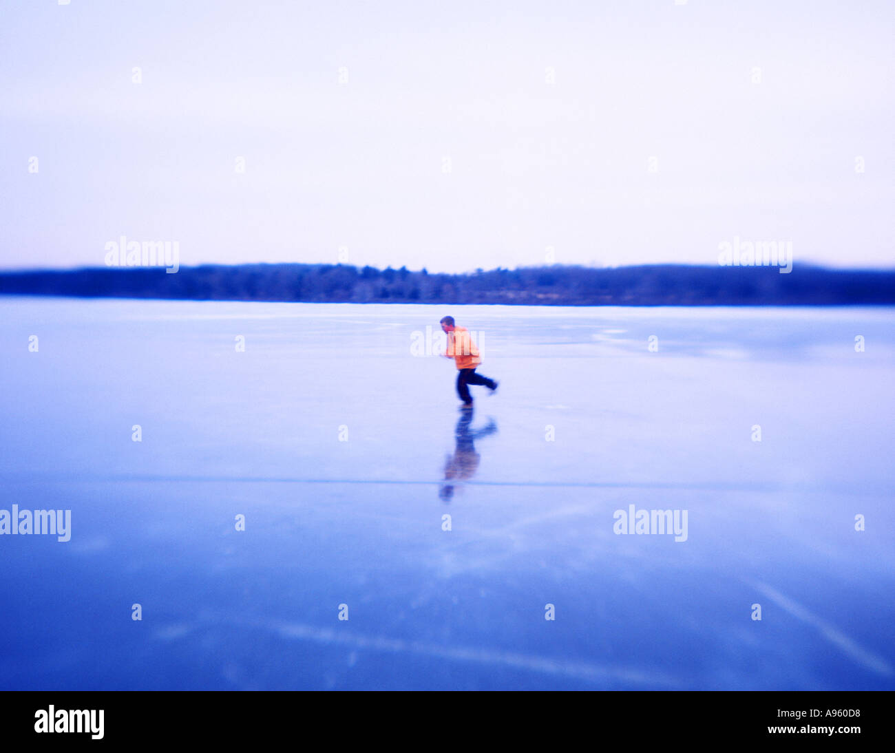 Boy wearing yellow jacket fonctionnant sur la glace Banque D'Images