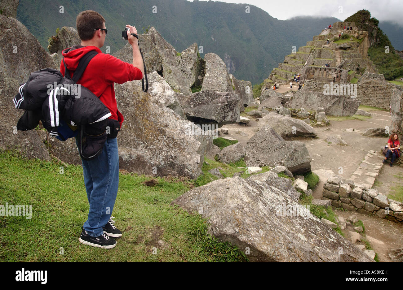 Un touriste de filmer et photographier l'ancien site inca de Machu Picchu au Pérou Amérique du Sud Banque D'Images
